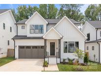 Beautiful modern farmhouse with white siding, black trim, and a two-car garage at 3937 Plainview Rd, Charlotte, NC 28208