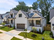 Stunning new construction, two-story home with white siding, covered porch and a two-car garage at 3945 Plainview Rd, Charlotte, NC 28208