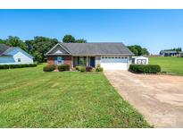 Charming single-story home with a well-maintained lawn, landscaping, and two-car garage at 402 Beaver Dam Church Rd, Shelby, NC 28152