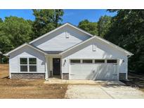 Charming new construction home with stone accents, white siding, an attached garage, and a well-manicured lawn at 4474 Pebblebrook Sw Cir, Concord, NC 28027