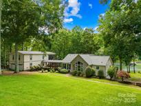 Charming lakeside home with lush lawn, mature trees, and attached guest house at 698 Normandy Rd, Mooresville, NC 28117
