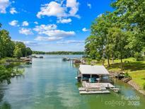 Beautiful lake view featuring a private dock and boat slip on a sunny day at 698 Normandy Rd, Mooresville, NC 28117