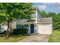Charming two-story home with a well-manicured lawn, attached garage, and inviting blue door at 7643 Monarch Birch Ln, Charlotte, NC 28215