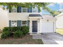 Charming two-story home featuring a single-car garage and a well-maintained front yard with lush greenery and dark blue shutters at 7643 Monarch Birch Ln, Charlotte, NC 28215