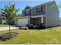 Charming two-story home featuring a well-manicured lawn, a two car garage, and a welcoming front porch at 811 Constantine Rd, Richburg, SC 29729