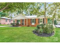 Charming brick home featuring a well-maintained lawn and mature trees at 835 Carrington Dr, Charlotte, NC 28214