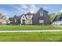 Beautiful home exterior with dark brick, light accents, professionally landscaped yard, and covered windows at 10119 Laurier Ln, Huntersville, NC 28078