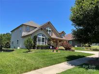 Charming two-story home featuring a well-manicured lawn and inviting curb appeal at 1156 Mckee Farm Ln, Belmont, NC 28012