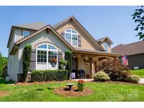 Charming two-story home featuring a well-manicured lawn, flowerbeds, and decorative shutters at 1156 Mckee Farm Ln, Belmont, NC 28012