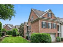 Brick townhouse with green shutters and a well-manicured lawn at 11724 Easthampton Cir, Charlotte, NC 28277