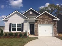 Charming one-story home with stone accents, covered entry, and a two-car garage, nestled on a well-maintained lot at 1242 Langston Ln, Salisbury, NC 28144
