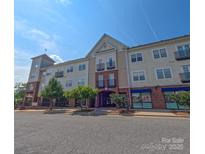 Attractive condo building with brick and siding exterior featuring balconies on a sunny day at 1410 4Th Street Nw Dr # 303, Hickory, NC 28601