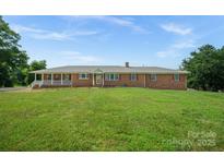 Charming brick home with a welcoming front porch and well-manicured lawn at 14411 Eastfield Rd, Huntersville, NC 28078