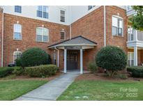 Inviting brick building entrance features well-manicured landscaping and covered entryway with ample natural light at 14624 Via Sorrento Dr # 6206, Charlotte, NC 28277