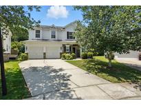 Charming two-story home featuring a manicured lawn, inviting entrance, and a convenient two-car garage at 15508 Normans Landing Dr, Charlotte, NC 28273