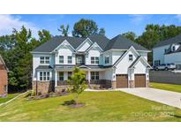 Attractive two-story home featuring a manicured lawn, stone accents, and a two-car garage at 15818 Sparrowridge Ct, Charlotte, NC 28278
