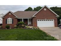 Charming single-story brick home featuring an attached two-car garage and well-maintained landscaping at 1764 Pipers Ridge Nw Cir, Conover, NC 28613