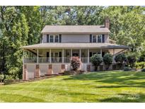 Charming two-story home featuring a spacious front porch and a well-manicured lawn surrounded by mature trees at 408 Camelot Dr, Salisbury, NC 28144