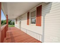 Inviting front porch with red painted wood and white siding, offering a cozy outdoor space at 411 S Central Ave, Landis, NC 28088
