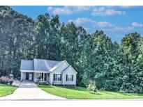 Charming single-story home with a manicured lawn, complemented by a lush, wooded backdrop at 5437 Mallard Ln, Gastonia, NC 28052
