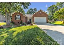 Charming brick home featuring an attached two-car garage, well-manicured lawn, and inviting front porch at 5476 Twelve Oak Ln, Conover, NC 28613