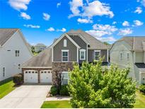 Charming two-story home features a three-car garage, stone accents, and a beautifully landscaped front yard at 586 Brookhaven Dr, Fort Mill, SC 29708