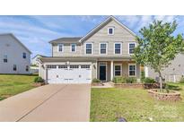 Charming two-story home featuring a two-car garage and a well-manicured front yard at 7079 Waterwheel Sw St, Concord, NC 28025
