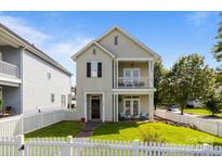Charming two-story home with a double balcony and a well-manicured lawn enclosed by a white picket fence at 9704 Grier Springs Ln, Charlotte, NC 28213