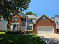 Charming two-story home featuring a brick facade, manicured lawn, and an attached two-car garage at 10607 Old Bridge Ln, Charlotte, NC 28269