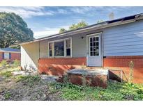Exterior view of house with red brick foundation and white door with window panes at 112 Harmony Trl, Gastonia, NC 28056