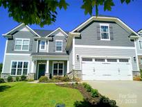 Charming two-story home with grey siding, a two-car garage, and a well-manicured lawn at 1141 Overlake Dr, Belmont, NC 28012