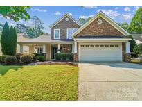 Charming two-story home featuring a stone facade, manicured lawn, and a two-car garage at 1237 Saint Johns Ave, Matthews, NC 28104