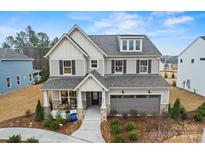 Stunning two-story home with a welcoming front porch, stone accents, manicured landscaping, and a two-car garage at 2192 Millennium Dr # 91, Lancaster, SC 29720