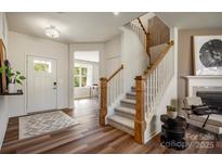 Inviting entryway with wood floors, white door, and staircase with wood railing at 2198 Millennium Dr # 90, Lancaster, SC 29720