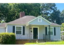 Charming single-story home featuring gray siding, black shutters, and a brick-accented porch with decorative iron railings at 2405 Greenland Ave, Charlotte, NC 28208