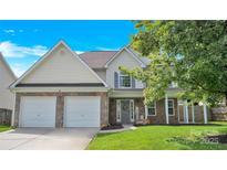 Charming two-story home featuring a stone facade, two-car garage, and inviting front porch with seasonal decorations at 280 Glenn Allen Rd, Mooresville, NC 28115