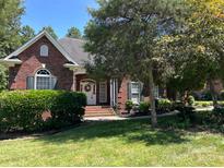 Charming, brick home with a manicured lawn, mature trees, and a welcoming entrance at 2909 Arbor Knl, Concord, NC 28025