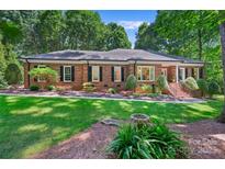 Charming brick home boasts a lush front yard with manicured landscaping and a welcoming entrance at 5008 Saddle Horn Trl, Weddington, NC 28104