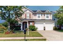 Charming two-story home with a two-car garage and well-manicured lawn at 6313 Woodland Commons Dr, Charlotte, NC 28269