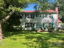 Traditional two-story home with green shutters and a red roof, framed by mature trees and a green lawn at 6708 Nutcracker Pl, Charlotte, NC 28212