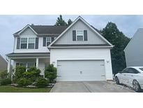Charming two-story home with white siding and a two-car garage, nicely landscaped with lawn and bushes at 8330 Kneller St, Charlotte, NC 28215