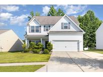 Charming two-story home with a manicured lawn, white siding, and a spacious two-car garage at 8330 Kneller St, Charlotte, NC 28215