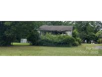 This property is an older home with a large yard surrounded by trees at 9924 Horton Rd, Charlotte, NC 28278