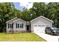 Charming single-story home with gray siding, brick accents, and a well-manicured lawn, shaded by mature trees in the front yard at 1005 8Th Sw Ave, Conover, NC 28613