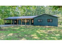 Charming, newly renovated one-story brick home featuring a metal roof and covered carport in a wooded setting at 155 Mcallister Rd, Statesville, NC 28625