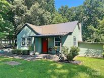 Charming single-Gathering home with a cozy front porch, metal roof, and well-maintained landscaping and bright red door at 201 Barnes Ln, Stony Point, NC 28678