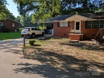 Charming brick home with a covered carport, front porch swing, and mature trees in a tranquil setting at 2261 Felly Ln, Lancaster, SC 29720