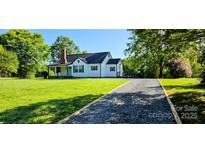 Charming home featuring a well-maintained lawn, gravel driveway and a covered porch at 4501 E Highway 27 Hwy, Iron Station, NC 28080