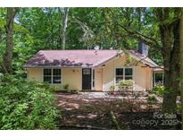 Charming one-story home with light yellow siding, mature trees, and well-maintained landscaping at 5534 Great Wagon Rd, Charlotte, NC 28215