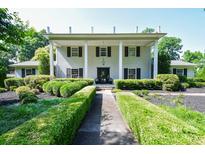 Stately two-story home featuring manicured hedges and a covered front porch with classic white columns at 711 Yadkin St, Albemarle, NC 28001